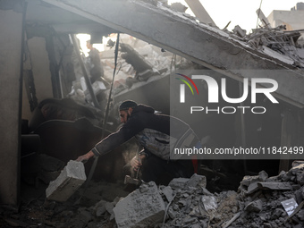 Palestinians inspect the damage after an Israeli strike on the Nuseirat refugee camp in the central Gaza Strip on December 7, 2024, amid the...