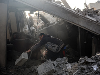 Palestinians inspect the damage after an Israeli strike on the Nuseirat refugee camp in the central Gaza Strip on December 7, 2024, amid the...