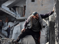 Palestinians inspect the damage after an Israeli strike on the Nuseirat refugee camp in the central Gaza Strip on December 7, 2024, amid the...