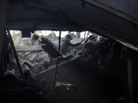 A Palestinian man stands atop the rubble of a building, destroyed in an Israeli strike, in the Nuseirat refugee Camp in the central Gaza Str...