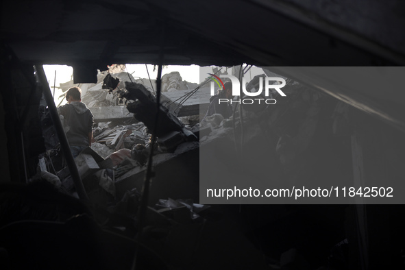 Palestinians inspect the damage after an Israeli strike on the Nuseirat refugee camp in the central Gaza Strip on December 7, 2024, amid the...