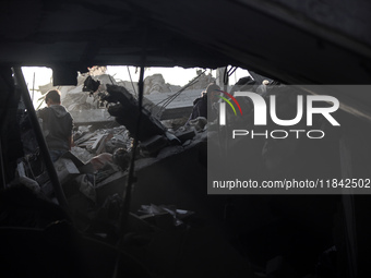 Palestinians inspect the damage after an Israeli strike on the Nuseirat refugee camp in the central Gaza Strip on December 7, 2024, amid the...