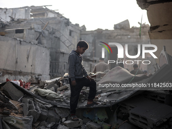 Palestinians inspect the damage after an Israeli strike on the Nuseirat refugee camp in the central Gaza Strip on December 7, 2024, amid the...