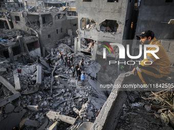 Palestinians inspect the damage after an Israeli strike on the Nuseirat refugee camp in the central Gaza Strip on December 7, 2024, amid the...