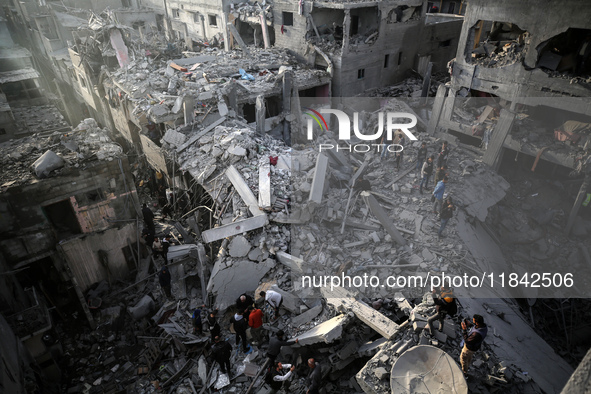 Palestinians inspect the damage after an Israeli strike on the Nuseirat refugee camp in the central Gaza Strip on December 7, 2024, amid the...