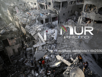 Palestinians inspect the damage after an Israeli strike on the Nuseirat refugee camp in the central Gaza Strip on December 7, 2024, amid the...