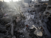 Palestinians inspect the damage after an Israeli strike on the Nuseirat refugee camp in the central Gaza Strip on December 7, 2024, amid the...