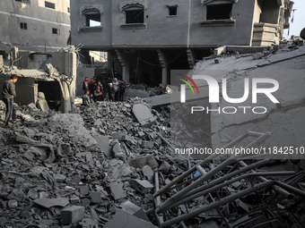 Palestinians inspect the damage after an Israeli strike on the Nuseirat refugee camp in the central Gaza Strip on December 7, 2024, amid the...