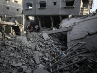 Palestinians inspect the damage after an Israeli strike on the Nuseirat refugee camp in the central Gaza Strip on December 7, 2024, amid the...