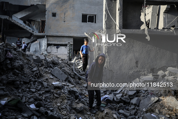 Palestinians inspect the damage after an Israeli strike on the Nuseirat refugee camp in the central Gaza Strip on December 7, 2024, amid the...