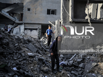 Palestinians inspect the damage after an Israeli strike on the Nuseirat refugee camp in the central Gaza Strip on December 7, 2024, amid the...