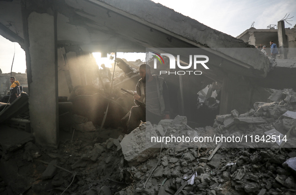 Palestinians inspect the damage after an Israeli strike on the Nuseirat refugee camp in the central Gaza Strip on December 7, 2024, amid the...