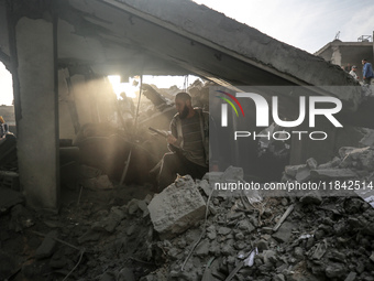 Palestinians inspect the damage after an Israeli strike on the Nuseirat refugee camp in the central Gaza Strip on December 7, 2024, amid the...