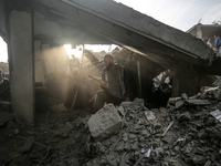 Palestinians inspect the damage after an Israeli strike on the Nuseirat refugee camp in the central Gaza Strip on December 7, 2024, amid the...