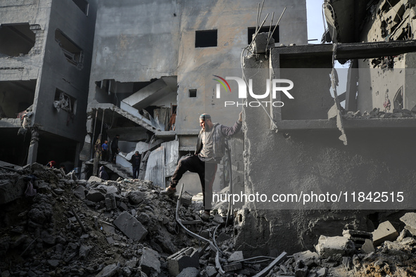 Palestinians inspect the damage after an Israeli strike on the Nuseirat refugee camp in the central Gaza Strip on December 7, 2024, amid the...