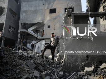 Palestinians inspect the damage after an Israeli strike on the Nuseirat refugee camp in the central Gaza Strip on December 7, 2024, amid the...