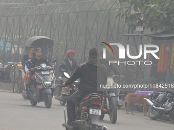 People walk during a cold and foggy day in Siliguri, India, on December 7, 2024. (