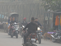 People walk during a cold and foggy day in Siliguri, India, on December 7, 2024. (