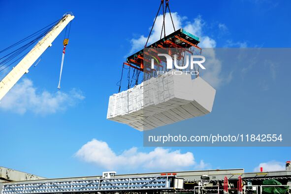 A cargo ship unloads imported pulp at the Xilian terminal of Qingdao Port in Qingdao, China, on December 7, 2024. 