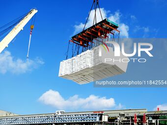 A cargo ship unloads imported pulp at the Xilian terminal of Qingdao Port in Qingdao, China, on December 7, 2024. (