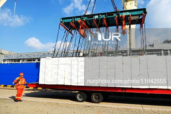 A cargo ship unloads imported pulp at the Xilian terminal of Qingdao Port in Qingdao, China, on December 7, 2024. 