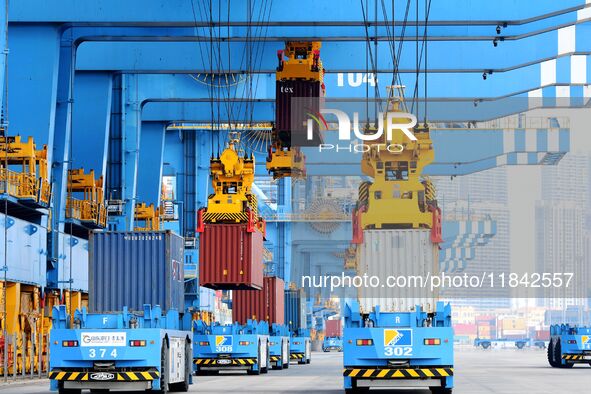 Cargo ships load and unload foreign trade containers at the automated terminal of Qingdao Port in Qingdao, China, on December 7, 2024. 