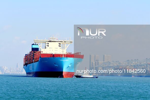 A cargo ship sails towards a foreign trade container terminal at Qianwan Port in Qingdao, China, on December 7, 2024. 