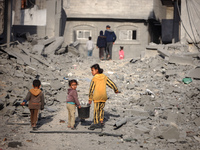 Palestinian children walk among the rubble of a building, destroyed in an Israeli strike, in the Nuseirat refugee Camp in the central Gaza S...