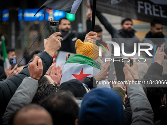 A representation of the Syrian people waves Syrian flags and chants for freedom in front of the European Parliament in Brussels, Belgium, on...