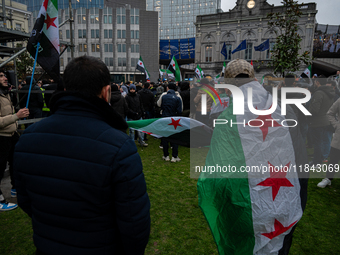 A representation of the Syrian people waves Syrian flags and chants for freedom in front of the European Parliament in Brussels, Belgium, on...