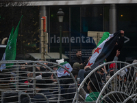 A representation of the Syrian people waves Syrian flags and chants for freedom in front of the European Parliament in Brussels, Belgium, on...