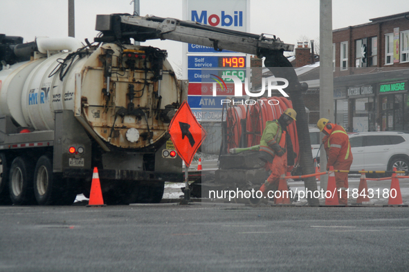 Workers use a vacuum truck to unclog a sewer drain in Mississauga, Ontario, Canada, on December 4, 2024. 