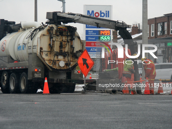 Workers use a vacuum truck to unclog a sewer drain in Mississauga, Ontario, Canada, on December 4, 2024. (