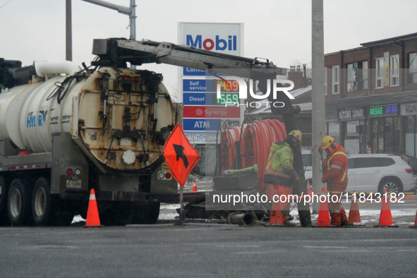 Workers use a vacuum truck to unclog a sewer drain in Mississauga, Ontario, Canada, on December 4, 2024. 