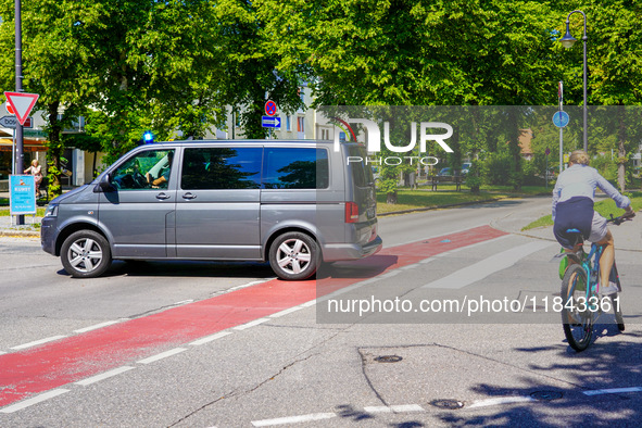 A German Crime Police van is on a mission with its flashing blue lights in Gauting, Bavaria, on July 5, 2022. A cyclist crosses the street n...