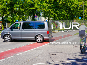 A German Crime Police van is on a mission with its flashing blue lights in Gauting, Bavaria, on July 5, 2022. A cyclist crosses the street n...