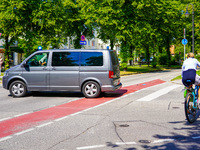 A German Crime Police van is on a mission with its flashing blue lights in Gauting, Bavaria, on July 5, 2022. A cyclist crosses the street n...