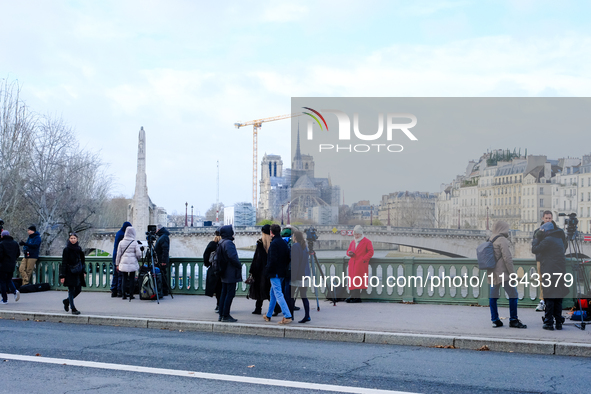 Television journalists film Notre Dame Cathedral. 