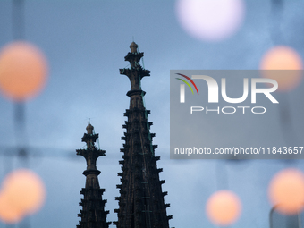 Christmas light decorations hang with the Dom Cathedral in the background in Cologne, Germany, on December 7, 2024. (