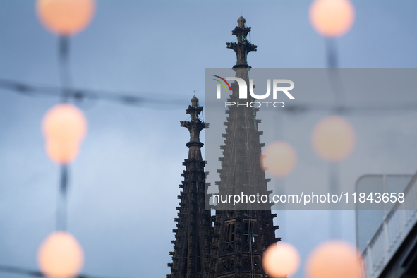 Christmas light decorations hang as Dom Cathedral is seen in the background in Cologne, Germany, on December 7, 2024. 