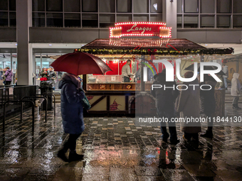 Umbrellas adorn the festive scene in Starnberg, Bavaria, Germany, on December 7, 2024, as the Christmas market embraces the charm of a rainy...