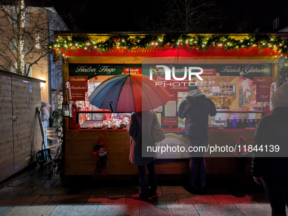 Umbrellas adorn the festive scene in Starnberg, Bavaria, Germany, on December 7, 2024, as the Christmas market embraces the charm of a rainy...