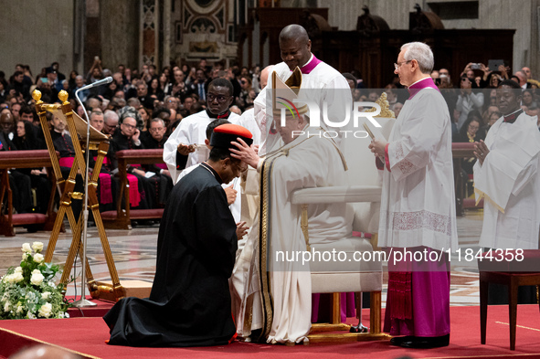 Pope Francis places the biretta upon the head of newly appointed Indian cardinal Jacob Koovakad during an Ordinary Public Consistory for the...