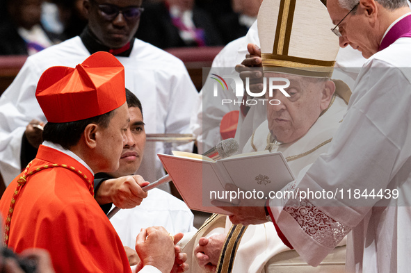 Philippine Cardinal Pablo Virgilio Siongco David (L) receives his biretta as he is appointed cardinal by Pope Francis (R) during a consistor...