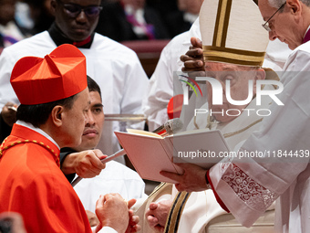 Philippine Cardinal Pablo Virgilio Siongco David (L) receives his biretta as he is appointed cardinal by Pope Francis (R) during a consistor...