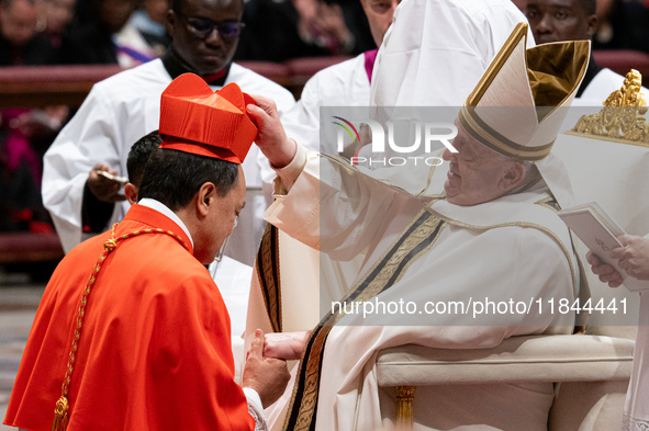 Philippine Cardinal Pablo Virgilio Siongco David (L) receives his biretta as he is appointed cardinal by Pope Francis (R) during a consistor...