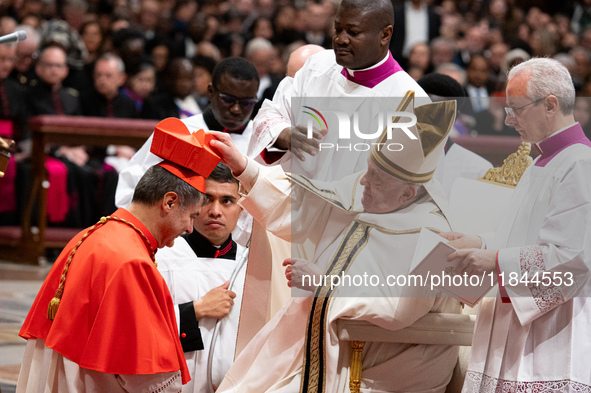 Roberto Repole, Archbishop of Turin and Bishop of Susa, Italy, right, receives the cardinals' biretta hat and ring from Pope Francis, left,...