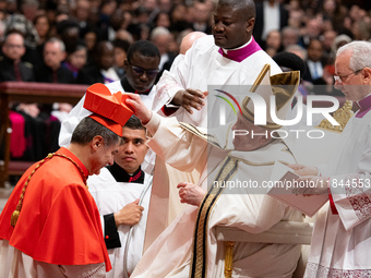 Roberto Repole, Archbishop of Turin and Bishop of Susa, Italy, right, receives the cardinals' biretta hat and ring from Pope Francis, left,...