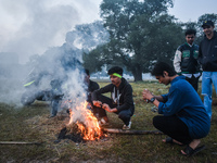 Men warm themselves by a fire on a cold winter morning in Kolkata, India, on December 8, 2024. (