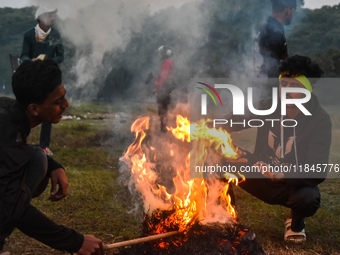 Men warm themselves by a fire on a cold winter morning in Kolkata, India, on December 8, 2024. (